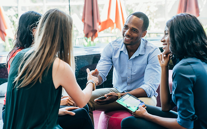 A group of four sitting down and interacting