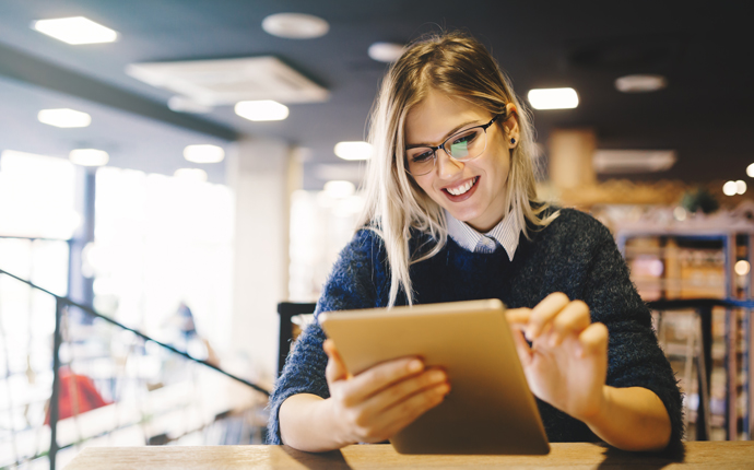 office employee smiling while using a tablet device