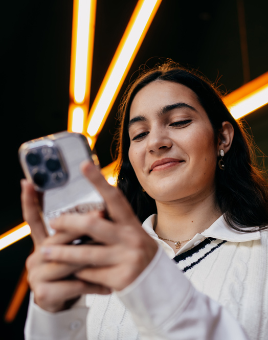 A happy PayPal customer using her cellphone