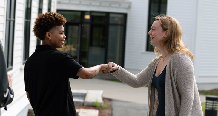 New England College staff member and student greeting each other