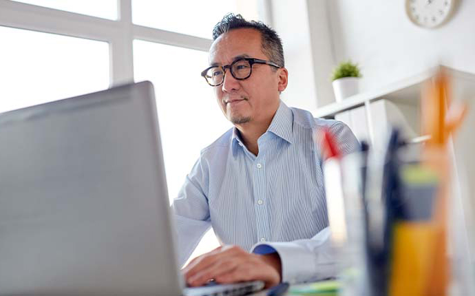 Business person with glasses, working at a computer